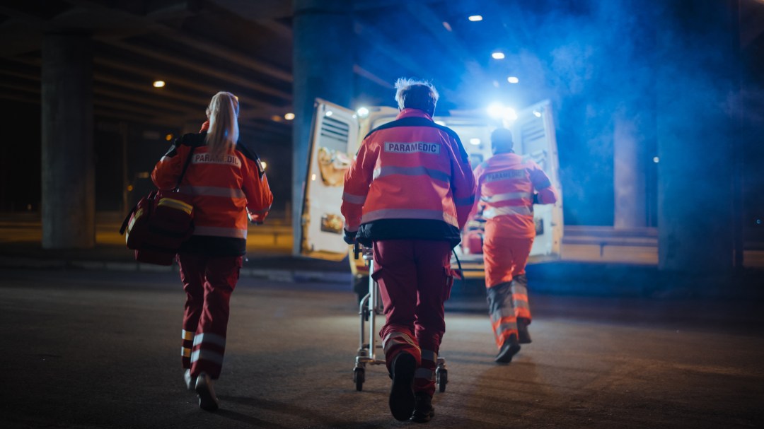 A team of EMS paramedics provide assistance to a patient